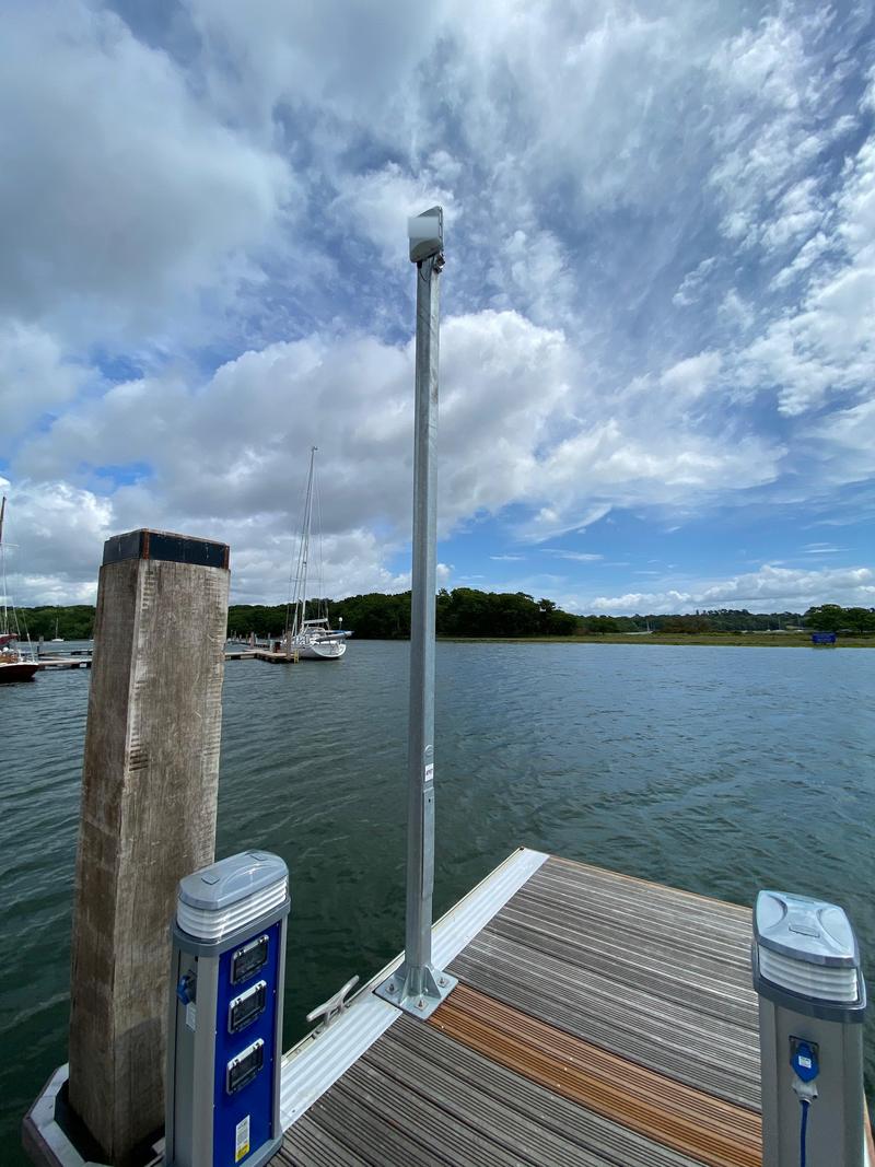 An access point on a galvanised post at the edge of a pontoon, looking down an open channel of water towards the far bank